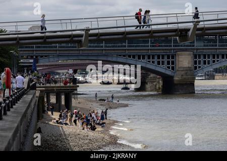 Grandi distese di rocce, ciottoli e spiagge sabbiose di bijou sono esposte sul Tamigi, mentre la gente sta allagando fango con la bassa marea, Londra, Regno Unito Foto Stock