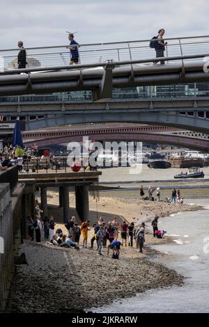 Grandi distese di rocce, ciottoli e spiagge sabbiose di bijou sono esposte sul Tamigi, mentre la gente sta allagando fango con la bassa marea, Londra, Regno Unito Foto Stock