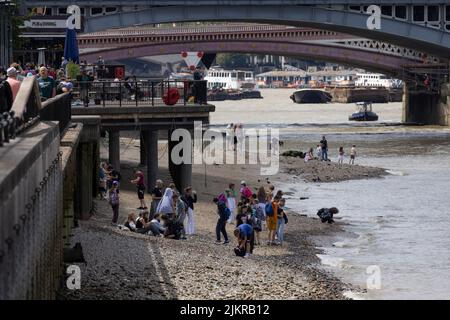 Grandi distese di rocce, ciottoli e spiagge sabbiose di bijou sono esposte sul Tamigi, mentre la gente sta allagando fango con la bassa marea, Londra, Regno Unito Foto Stock