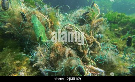 L'attrezzatura da pesca persa si trova sott'acqua sul fondale marino. Problema di attrezzi fantasma - qualsiasi attrezzo da pesca che è stato abbandonato, perso o altrimenti scartato. È così Foto Stock
