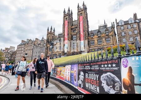 Edimburgo, Scozia, Regno Unito, 3rd agosto 2022. Edinburgh Festivals: Posters per gli spettacoli di frange del festival di Edimburgo nel loro solito posto sulle ringhiere sul Mound, con le torri della Assembly Hall che espongono i banner del festival Foto Stock