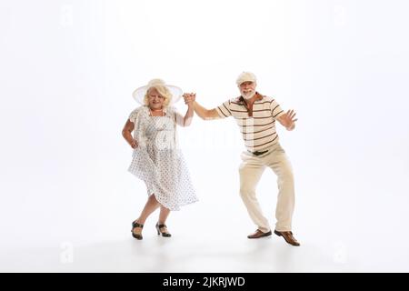 Ritratto di ballerini in stile retrò, uomo anziano e donna in vintage abbigliamento dancing swing isolato su sfondo bianco. Concetto di cultura, arte, musica Foto Stock