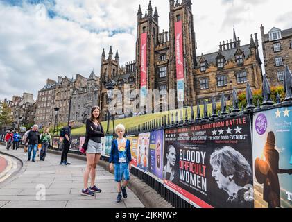 Edimburgo, Scozia, Regno Unito, 3rd agosto 2022. Edinburgh Festivals: Posters per gli spettacoli di frange del festival di Edimburgo nel loro solito posto sulle ringhiere sul Mound, con le torri della Assembly Hall che espongono i banner del festival Foto Stock