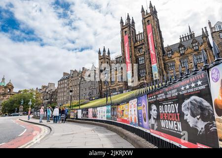 Edimburgo, Scozia, Regno Unito, 3rd agosto 2022. Edinburgh Festivals: Posters per gli spettacoli di frange del festival di Edimburgo nel loro solito posto sulle ringhiere sul Mound, con le torri della Assembly Hall che espongono i banner del festival Foto Stock