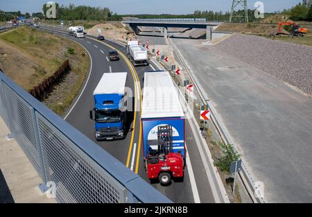 03 agosto 2022, Sassonia, Rötha: I veicoli lasciano la superstrada A72 vicino a Rötha, proprio accanto al cantiere per l'ultima sezione della superstrada. Mentre l'espansione dell'ultima sezione del A72 continua, il B95 intorno Espenhain è in fase di smantellamento. Un percorso ciclabile è attualmente in costruzione tra Borna e Rötha, utilizzando in gran parte le corsie esistenti del vecchio B95 come base. I lavori sul pezzo centrale continueranno fino a metà ottobre. Poi l'ex autostrada federale molto trafficata diventerà strada statale 242 con fiancheggianti strisce verdi e spazio per pedoni e ciclisti. Foto: Hendrik Schmidt/dpa Foto Stock