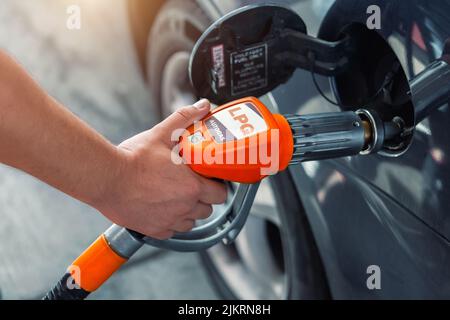 Vista dettagliata della pompa carburante autogas collegata con adattatore a nozle al serbatoio dell'auto per il rifornimento alla stazione di rifornimento del gas dell'auto. Rifornimento del veicolo con Foto Stock