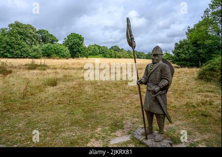 Ammira il campo di battaglia nella Battaglia di Hastings del 1066 con una scultura in legno di un guerriero normanno, Battaglia, East Sussex, Inghilterra. Foto Stock