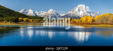 Vista panoramica del Monte Moran da Oxbow Bend accanto al fiume Snake di Grand Teton, Wyoming. Il colore degli alberi e dei cespugli cambia a causa del cambiamento autunnale in w Foto Stock