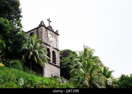 Torre dell'Orologio in pietra (Tour de l'Horloge) sulla collina accanto alla Cattedrale dell'Immacolata Concezione, vecchio edificio con orologio e Santa Croce, Victoria, Mahe Foto Stock