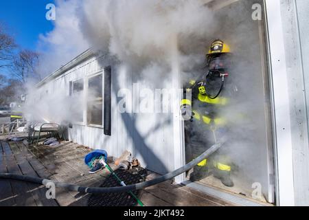 Un addetto alla sicurezza antincendio esce da casa alle 12:26 di mercoledì 28th febbraio 2018, i membri del Dipartimento dei vigili del fuoco di East Hampton hanno risposto al Foto Stock