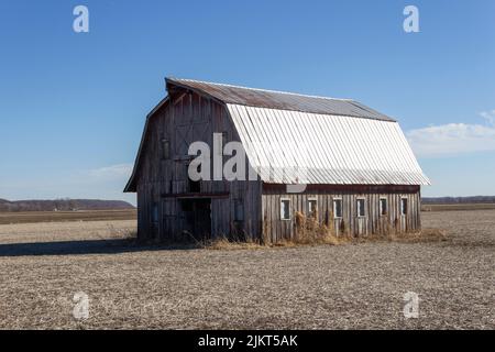 Vecchio fienile abbandonato in un campo aperto Foto Stock