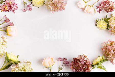 Autunno composizione creativa rose, fiori di hydrangea su sfondo grigio. Autunno, sfondo autunno. Disposizione piatta, vista dall'alto, spazio di copia Foto Stock