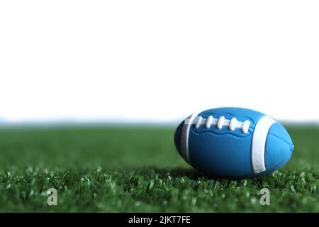 Immagine selettiva del fuoco della palla di rugby sull'erba del campo di rugby isolata su sfondo bianco Foto Stock
