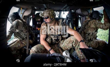 Gli airman della Guardia Nazionale aerea del Kentucky 123rd Special Tactics Squadron caricano un elicottero UH-60 Blackhawk con attrezzatura salvavita alla base della Guardia Nazionale aerea del Kentucky a Louisville, Ky., 30 luglio 2022. In risposta alle inondazioni nel Kentucky orientale, l'unità ha coordinato 29 missioni di soccorso ad ala rotante, ha salvato 19 persone e due cani, e ha recuperato quattro corpi. I loro sforzi di comando e controllo hanno anche facilitato l'assistenza o il recupero di 40 persone. (STATI UNITI Foto della Guardia Nazionale dell'aria dello staff Sgt. Usura Clayton) Foto Stock