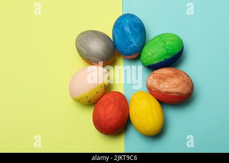 Un primo piano di uova di Pasqua isolato su uno sfondo blu e giallo Foto Stock