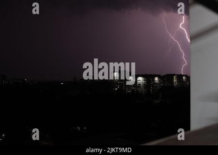 Una vista serale della città con luci segnate nel cielo scuro Foto Stock