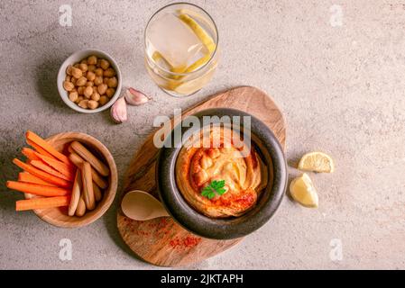 Hummus fatto in casa con bastoncini di carota, con olio d'oliva, paprika, limone Foto Stock