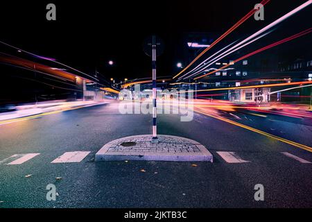 Un'esposizione lunga dei fari dell'automobile su un'autostrada scura di notte Foto Stock