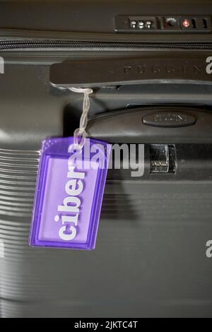 Un primo piano verticale di una valigia da viaggio con un tag Ciber Company. Foto Stock