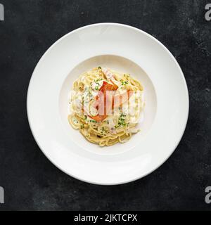 Una vista dall'alto della gustosa pasta di carbonara su un piatto bianco Foto Stock