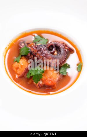 Stufato di polpo e pomodoro con prezzemolo in un ristorante Foto Stock