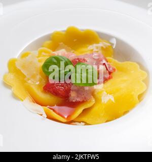 Tortellini con salsa di pomodoro rossa, parmigiano e basilico Foto Stock