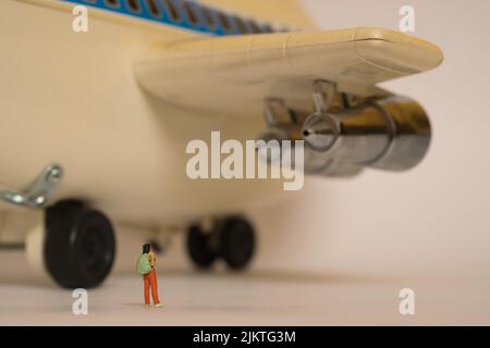 un enorme aeroplano, vista posteriore dove un viaggiatore con uno zaino sta davanti alle ruote Foto Stock