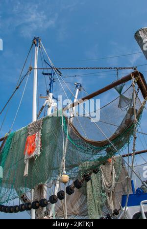 Un tiro a basso angolo di reti appese ai pescherecci da traino di un peschereccio Foto Stock