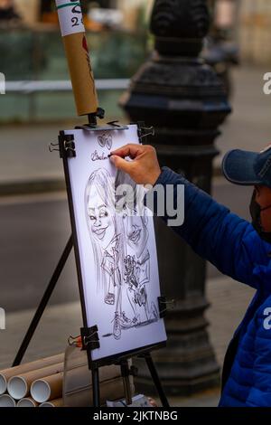 Barcellona, Spagna - 8 aprile 2022: Artista di strada che dipinge una caricatura sulla Rambla di Barcellona (Spagna), approccio selettivo al disegno. Foto Stock