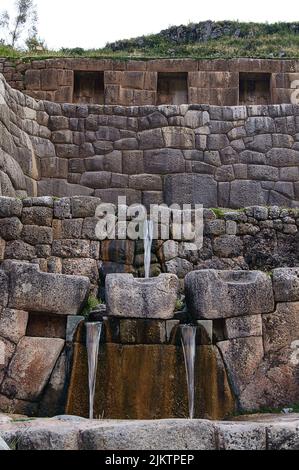 Un colpo verticale di Tambomachay con acqua di sorgente fresca a Cusco, Perù Foto Stock