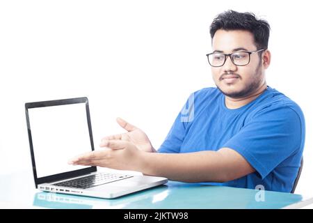 giovane uomo che punta le mani verso lo schermo vuoto del laptop Foto Stock