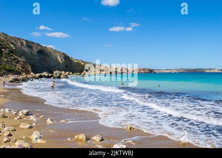 Le onde e il blu del mare Mediterraneo sulla spiaggia sabbiosa di Imgiebah Bay, vicino Selmun, Mellieha, Malta, nella bella giornata autunnale. Popolare sito di balneazione. Foto Stock
