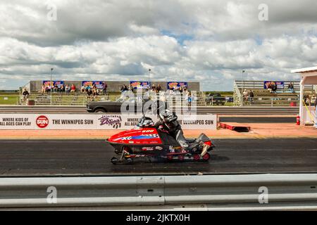 Motoslitta vs auto al Gimili Drag Race Motor Park speedway Foto Stock