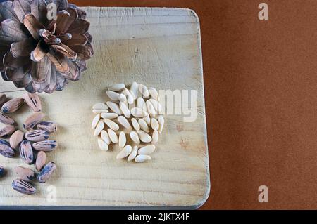 Cono di pino con i suoi pinoli appena raccolti. Foto Stock