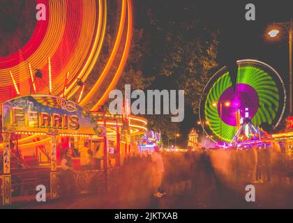 Le giostre illuminate in movimento presso la St Giles Fair di Oxford di notte Foto Stock