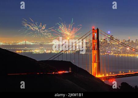 Una vista mozzafiato del Golden Gate Bridge con lo skyline della città di San Francisco e i fuochi d'artificio di notte Foto Stock