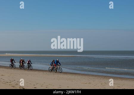 Mountain biker che pedalano sulla spiaggia vicino al mare vicino Egmond aan Zee nei Paesi Bassi Foto Stock