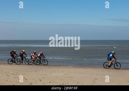 Mountain biker che pedalano sulla spiaggia vicino al mare vicino Egmond aan Zee nei Paesi Bassi Foto Stock