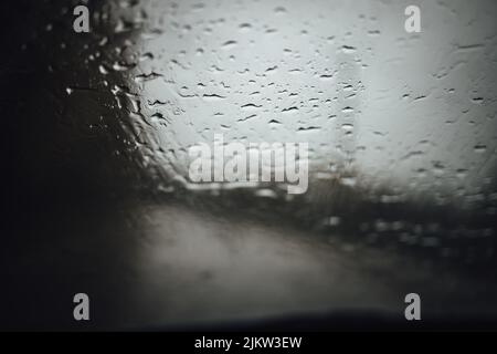 un primo piano di pioggia che cade sul vetro di un'auto Foto Stock