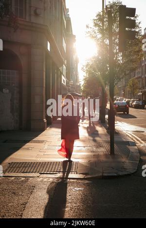 Una foto verticale di persone che camminano per Londra in una giornata di sole Foto Stock