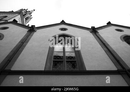 Un basso angolo di facciata di un vecchio edificio in scala di grigi Foto Stock