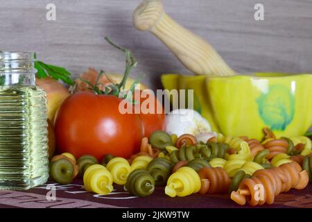 Un cibo sano, pasta colorata, pomodori e altri ingredienti, che forniscono benessere al nostro corpo. Foto Stock