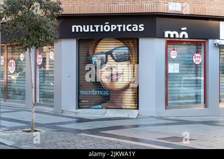 Arganda del Rey, Spagna. Dicembre 31, 2021. Facciata e recinzione in metallo con disegno, di un negozio di occhiali multiottici, in una piccola città di Madrid. Foto Stock