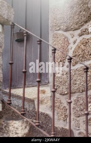 Le scale di pietra che conducono alla porta di legno anteriore Foto Stock
