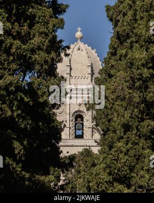 Un colpo verticale di una grande cupola della chiesa grande croce sulla tenda circondata da grandi alberi Foto Stock