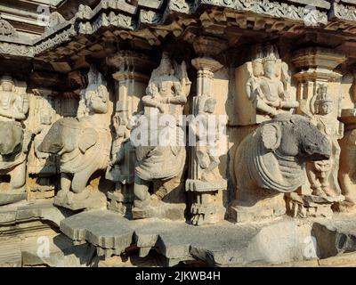 Foto di scorta di scultura antica rovinata di Dio della trinità indù seduto su elefante, idolo scolpito fuori gary colore granito luce del sole cadere su idolo, Pic Foto Stock