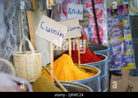 Barili di spezie nel mercato di Marrakech in Marocco con etichette di cumino e paprika Foto Stock