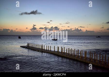Un bellissimo scatto di una banchina e yacht a vela contro il cielo crepuscolo al tramonto Foto Stock