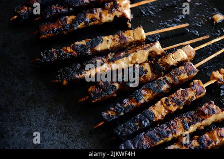Un primo piano di un delizioso barbecue leggermente bruciato sulle bacchette Foto Stock