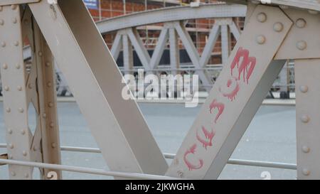 Un primo piano di costruzioni metalliche di un ponte con graffiti rossi Foto Stock